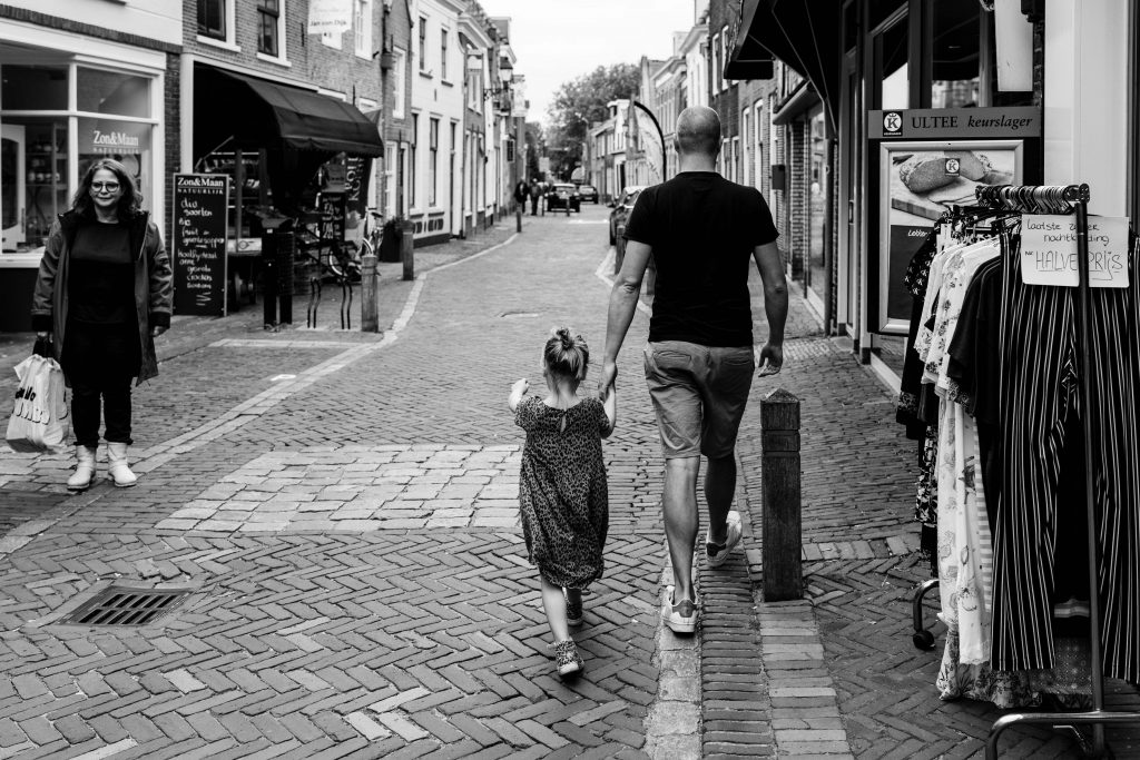 vader en dochter wandelen in een winkelstraat