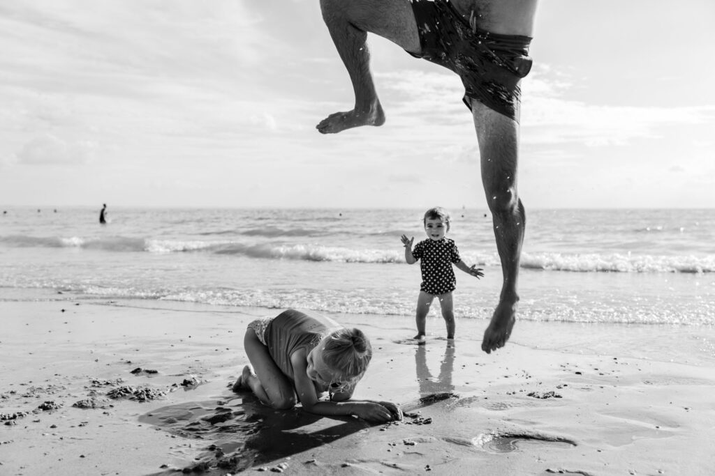 Familiefotografie Eindhoven Vader springt over kind heen op het strand